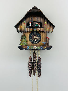 Wooden cuckoo clock with detailed design on a white background