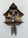 Wooden cuckoo clock with detailed design on a white background
