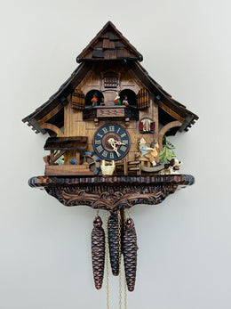 Wooden cuckoo clock with detailed design on a white background