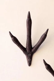 A dark brown, three-clawed bird-of-prey style wall hook with a screw-mounted base, shown against a plain off-white background.