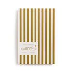 Pack of cheese knives with gold and white striped design on a white background