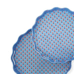 Two blue ceramic plates with red floral patterns on a white background