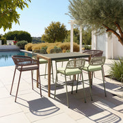 Outdoor patio set with a table and chairs near a pool