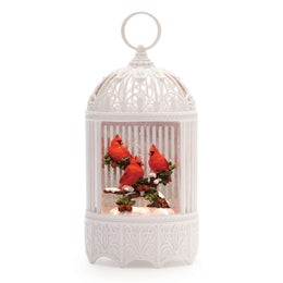 LED birdcage-style snow globe with red cardinals on pine branch and swirling glitter, 11 inches tall