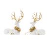 Two decorative deer figurines with gold antlers and wreaths on a white background