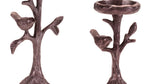 Two bronze-colored candle holders shaped like trees with birds on a white background
