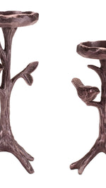 Two bronze-colored candle holders shaped like trees with birds on a white background