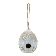 Decorative ceramic birdhouse with a pattern and green leaves on a white background