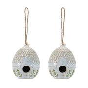 Two ceramic birdhouses with decorative patterns on a white background