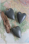 Set of six dark grey hand-carved stone hearts