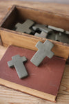 Metallic crosses on an old book with a wooden box in the background