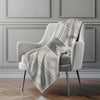 Plaid blanket draped over a chair in a room with gray walls and wooden flooring.