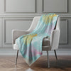 Colorful blanket draped over a chair in a room with gray walls.