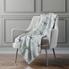 Light blue blanket with starfish pattern draped over a gray chair against a gray wall.