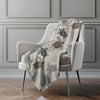 Blanket with turtle pattern draped over a chair in a room with gray walls.