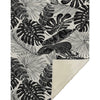 Tropical leaf patterned rug with black and white design on a beige background