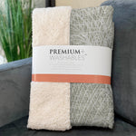 Folded blanket with 'Premium Washables' label on a couch