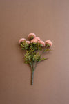 Artificial flower branch with pink flowers on a brown background