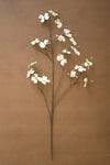 Artificial flower branch with white flowers on a brown background