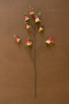 Artificial flower branch with pink buds on a brown background