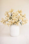 White vase with cream-colored flowers on a white background