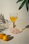 Glass with yellow liquid on a light surface with lemons and a plant