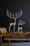 Decorative deer sculptures on a wooden table with a dark background