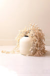 White vase with dried flowers on a light background