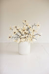 White vase with white flowers on a light background