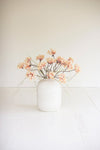 White vase with pink flowers on a white background
