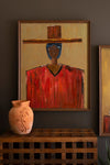 Framed abstract painting on a wall with a vase below