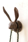 Decorative wall hook shaped like a rabbit head with a chain on a white background
