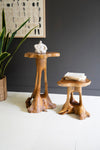 Two wooden side tables with a dark gray wall and plant in the background