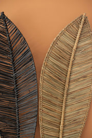 Two leaf-shaped wall decorations on a brown background