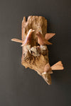 Wooden sculpture of birds on a branch against a dark background