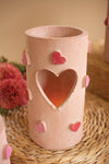 Ceramic vase with heart designs on a woven surface