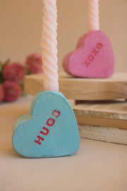 Heart-shaped wooden blocks with 'HUG' and 'Kiss' text on a blurred background