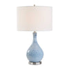 Table lamp with blue textured base and white shade on a white background