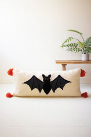 Decorative pillow with bat design on a plain background