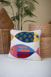 Decorative pillow with colorful fish pattern on a neutral background