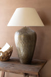 Decorative lamp with intricate design on a wooden table against a beige wall