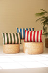 Striped cushions on wicker stools with a plant in the background