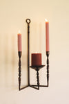 Decorative candle holder with three candles on a beige background
