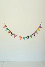 Colorful 'Happy Birthday' banner on a white wall
