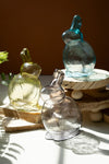 Three glass animal figurines on a wooden stand with a blurred background