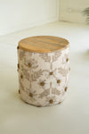 Small ottoman with floral pattern and wooden top on a white surface