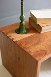 Wooden surface with a green candlestick and books on a plain background