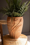 Decorative terracotta pot with plants on a textured surface