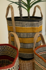 Woven planters with striped patterns on a neutral background