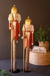 Two decorative nutcrackers with gold helmets and red suits on a dark surface.